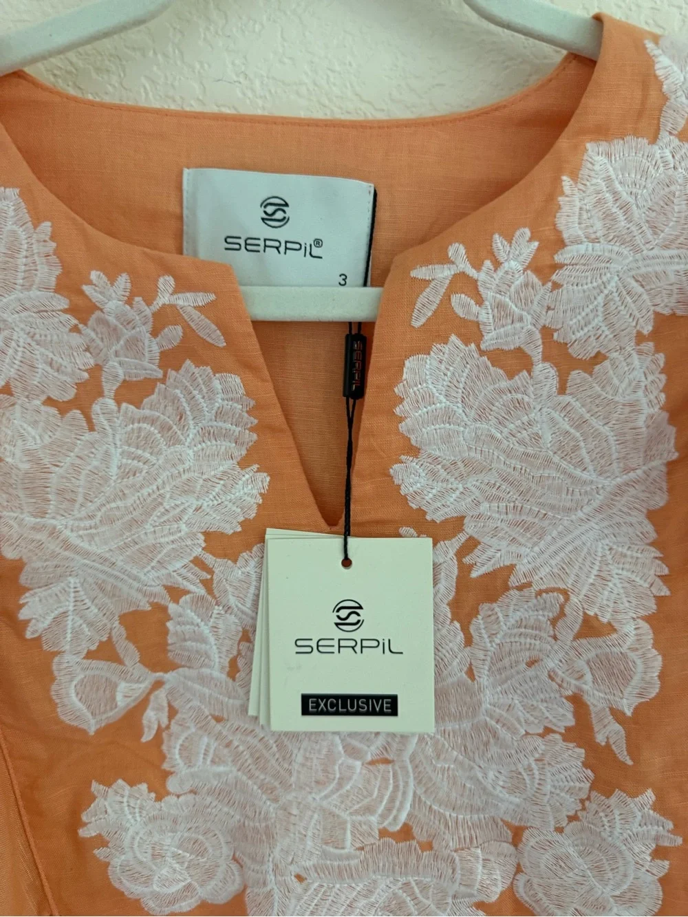 Blouse features split neckline with ties and voluminous embroidered puff sleeves